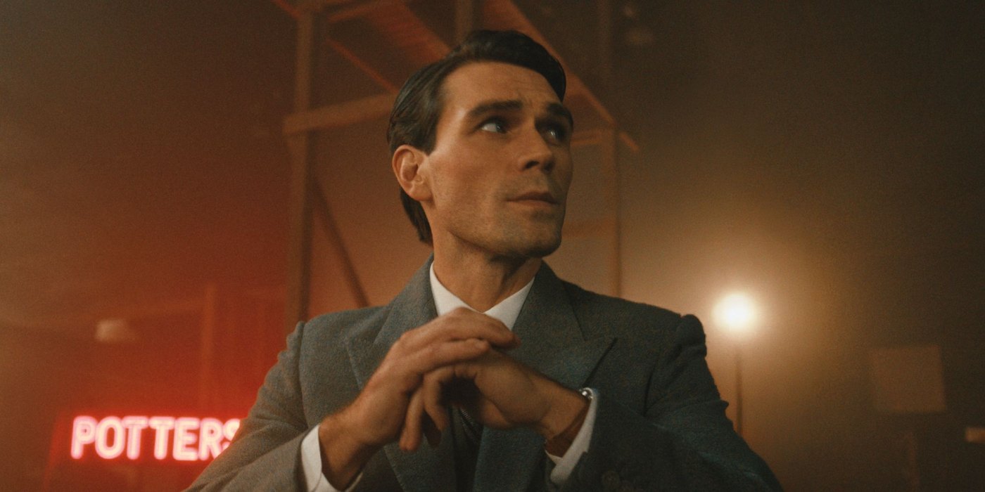 KJ Apa as Jimmy Stewart in a gray suit, hands clasped, with a red Potters neon sign behind him