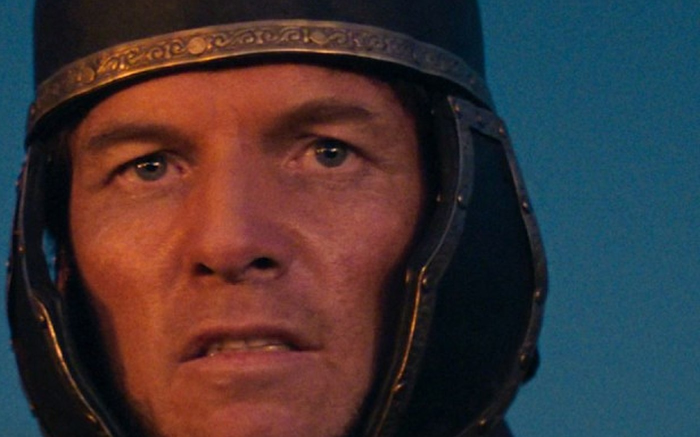 Jim Caviezel as King Herod in a dark metal helmet against blue sky in Zero A.D.